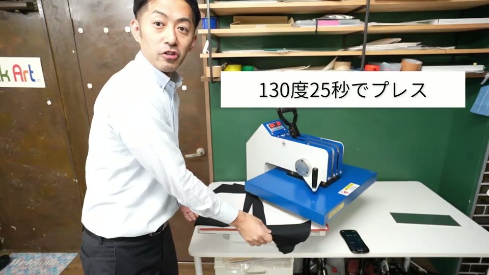 スウィング式の熱プレス機で黒いTシャツにプレスしている様子。テロップに「130度25秒でプレス」