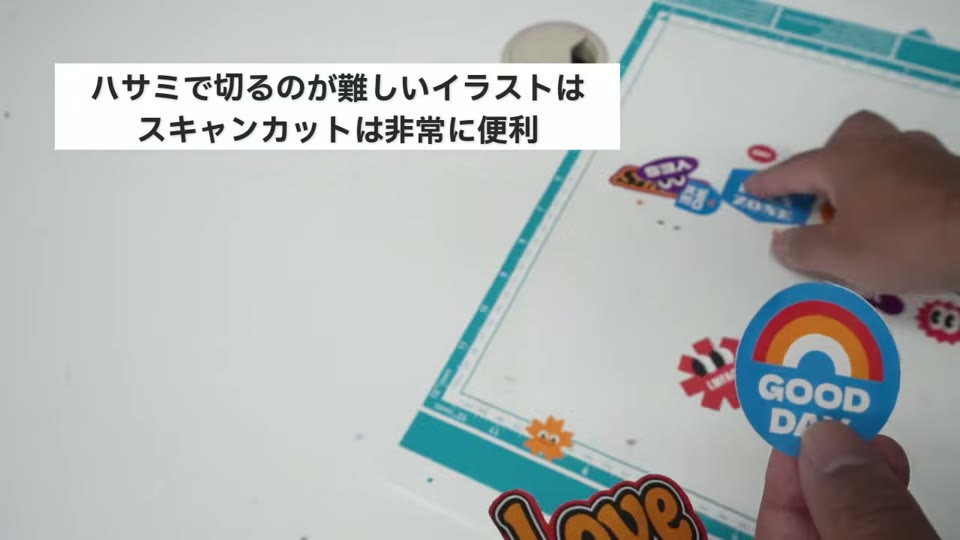 スキャンカットで切り抜いたGOOD DAYやLoveのステッカーを、マットから剥がしている手元