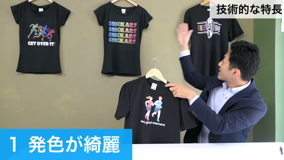 プリントした黒のドライTシャツをハンガーに掛けて見せ、テロップで発色が綺麗と紹介している様子