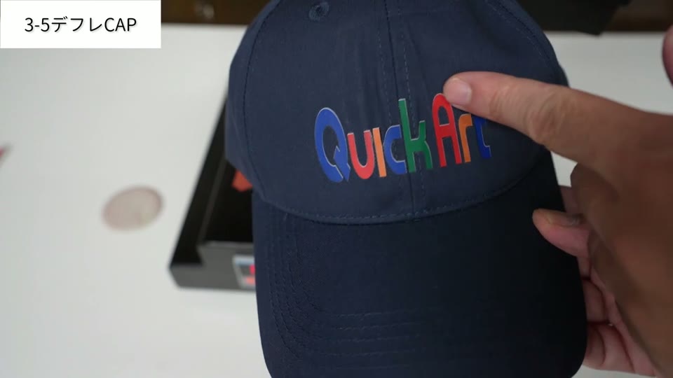 紺色のデフレキャップにカラフルなQuickArtのロゴがプリントされている