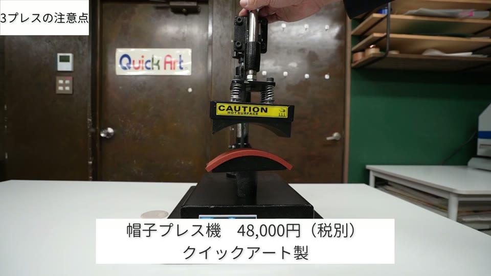 黒い本体にカーブした下ゴテが付いた帽子プレス機。テロップは帽子プレス機48,000円(税別)クイックアート製
