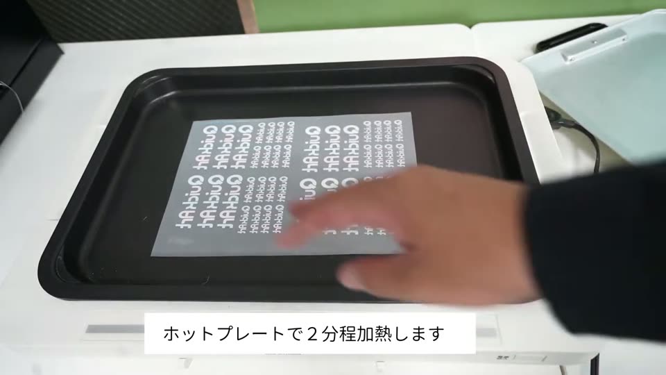 ホットプレートの上にパウダーをつけたフィルムを置いている様子
