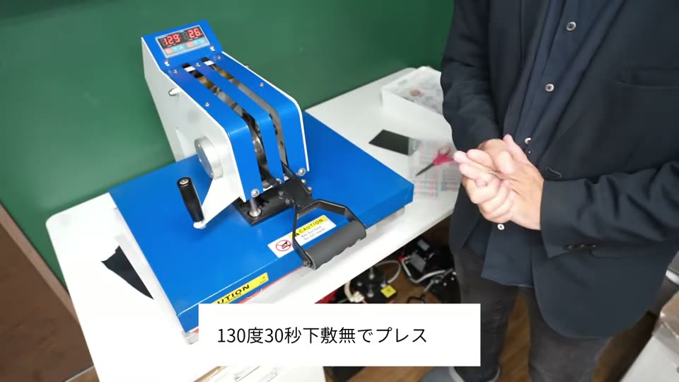 作業台40×50cmのプレス機で軍手をプレスしている様子。テロップは130度30秒下敷無でプレス