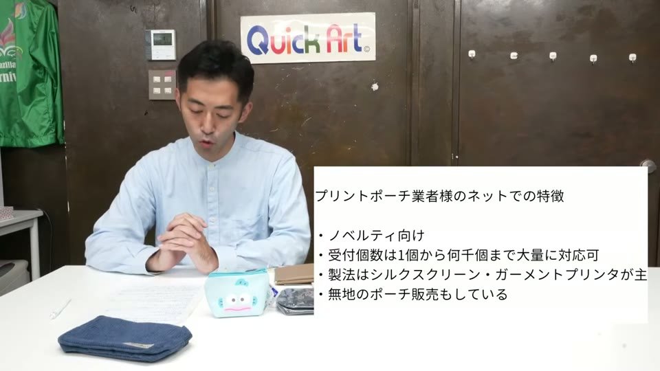 東京ショールームの机でポーチを前に解説している様子。画面に「プリントポーチ業者様のネットでの特徴:ノベルティ向け、受付個数は1個から何千個まで大量にも対応可、製法はシルクスクリーン・ガーメントプリンタが主、無地のポーチ販売もしている」