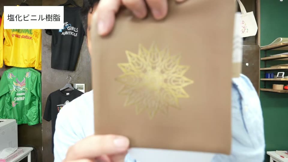 ベージュの塩化ビニル樹脂のポーチに、黄色い曼荼羅模様のデザインがプリントされている
