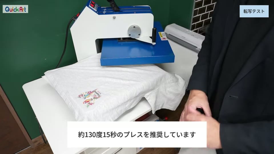 グレーのTシャツに転写フィルムを置き、青い熱プレス機でプレスしようとしている様子。約130度15秒のプレスを推奨していますというテロップ
