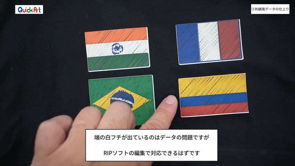 黒いTシャツにプリントした刺繍風の国旗の端に、白いフチが出ている部分を指で示している