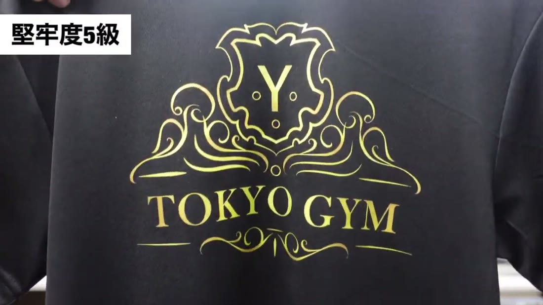 黒いドライTシャツに金色のロゴをプリント