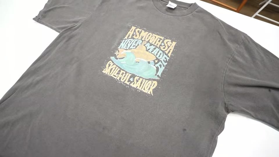 ピグメント加工のTシャツの正面に、白トナーで薄いデザインをプリントした仕上がり