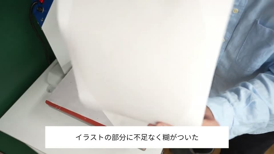 プレス機の上でプラスターシートを剥がし終えたところ。テロップはイラストの部分に不足なく糊がついた
