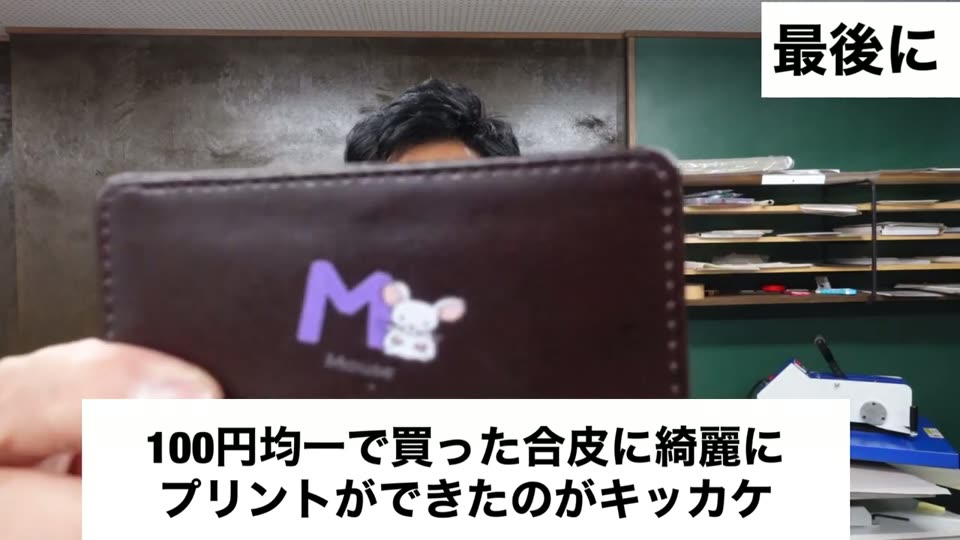 100円均一で買った茶色い合皮のカードケースに、紫色のロゴが転写されている。100円均一で買った合皮に綺麗にプリントができたのがキッカケというテロップ