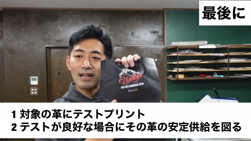 黒い革を持って説明している。1対象の革にテストプリント、2テストが良好な場合にその革の安定供給を図るというテロップ