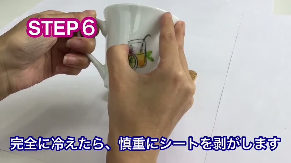 冷えたカップから、オーブンプリントシートのフィルムを慎重に剥がしているところ