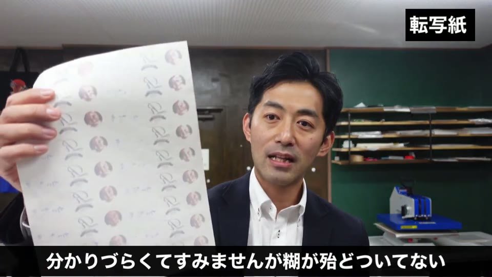 糊付けをしたあとの転写紙を見せ、印刷部分に糊がほとんど付いていないことを説明している場面