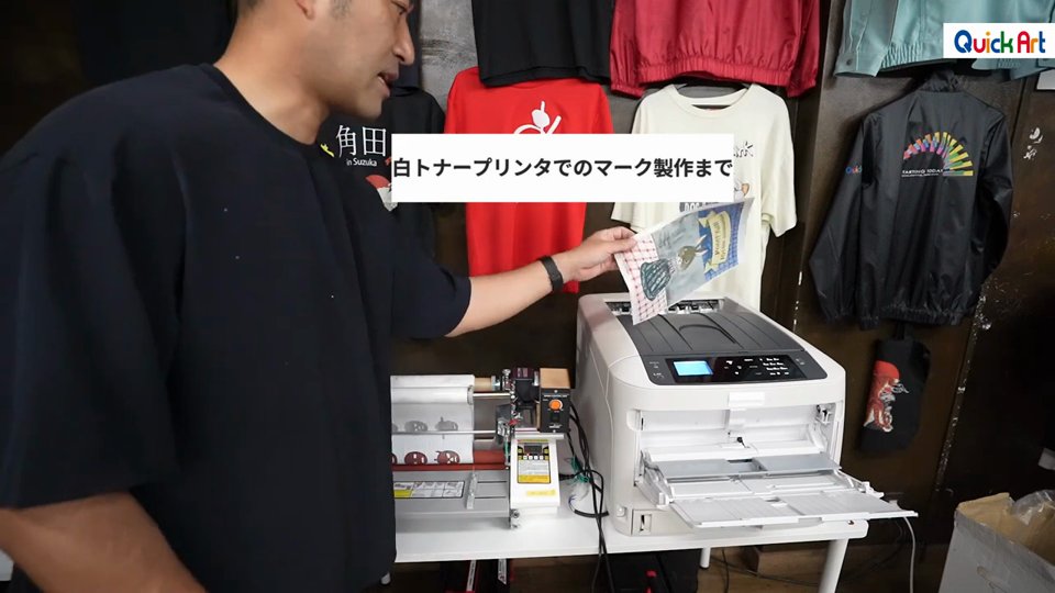 白トナープリンタから印刷されたA4のシートを取り出す様子
