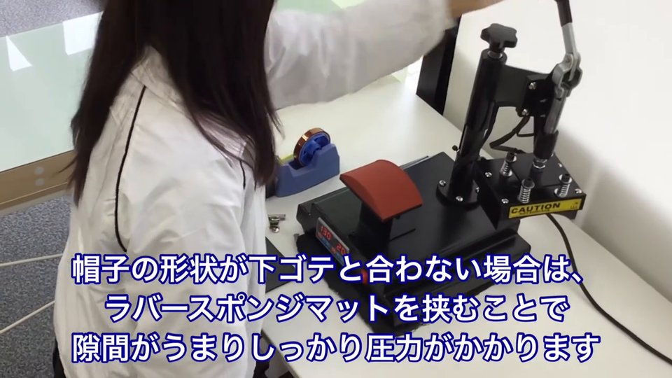 帽子プレス機の下ゴテに帽子をセットする前の様子。テロップ:帽子の形状が下ゴテと合わない場合は、ラバースポンジマットを挟むことで隙間がうまりしっかり圧力がかかります