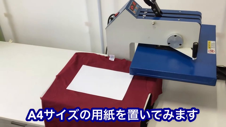 上ゴテを横にスイングさせ、下ゴテに置いたMサイズのTシャツにA4サイズの用紙を乗せた様子