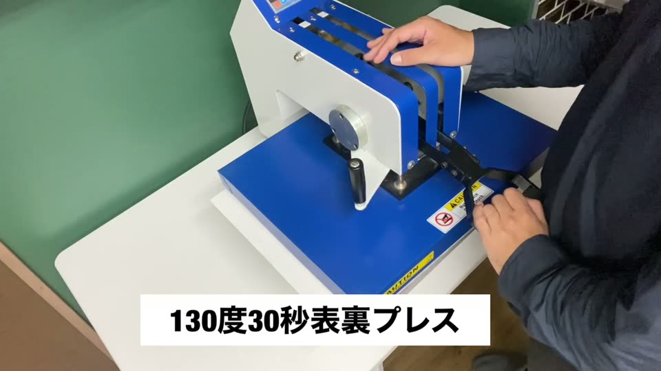 スイング式プレス機で抜ける転写紙を130度30秒表裏でプレスしている様子