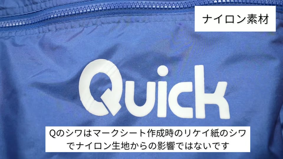 青いナイロンジャケットに、白のぷくぷくプリントで「Quick」の文字をプリントしたもの