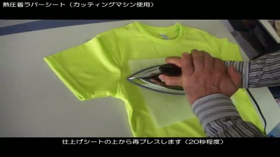 蛍光イエローのTシャツの文字の上に仕上げシートをのせ、アイロンで再プレスしているところ