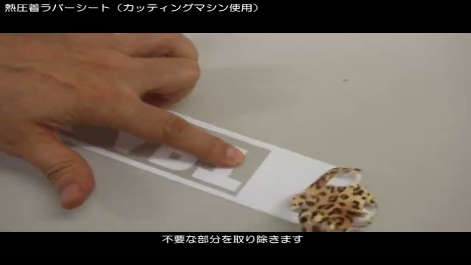 カットした柄入りラバーシートから、ピンセットで文字のまわりの不要な部分を取り除いているところ