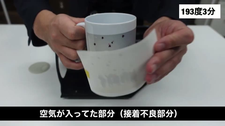 転写紙をはがしたマグカップ。空気が入っていた部分が接着不良になったと説明するテロップ