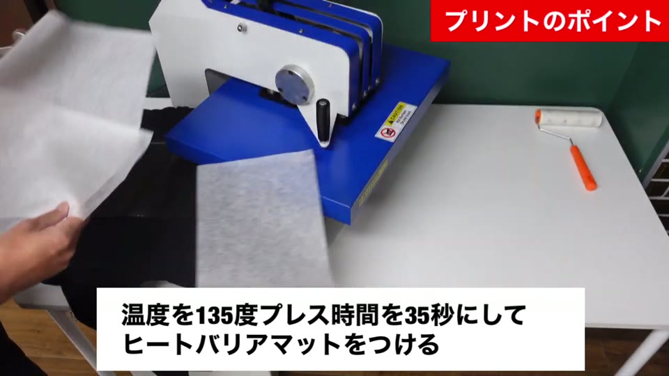 パーカーに乗せた転写マークの上にヒートバリアマットを重ねる様子。温度を135度プレス時間を35秒にしてヒートバリアマットをつけるとテロップが出ている