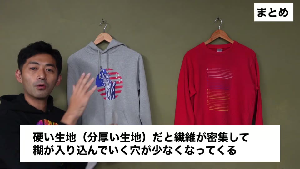 グレーのパーカーにプリントしたイラストに転写紙を当てて説明している様子。硬い生地(分厚い生地)だと繊維が密集して糊が入り込んでいく穴が少なくなってくるとテロップが出ている