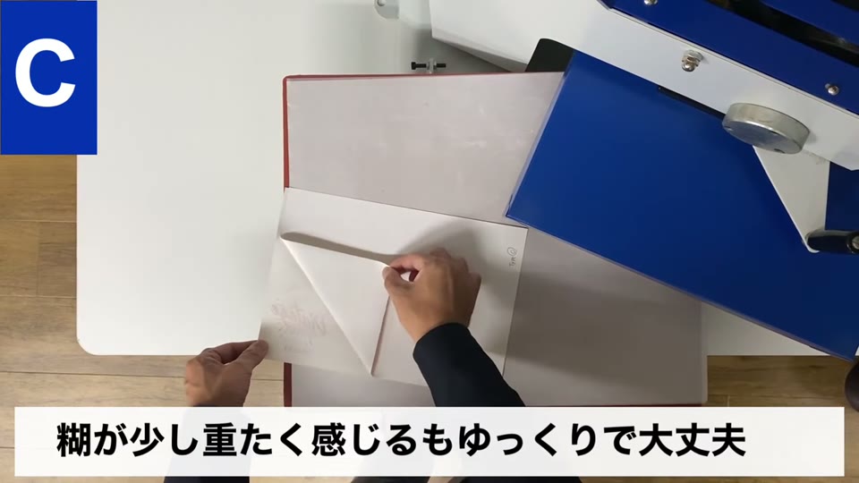 タイプCのシートを剥がしている手元と、糊が少し重たく感じるもゆっくりで大丈夫というテロップ