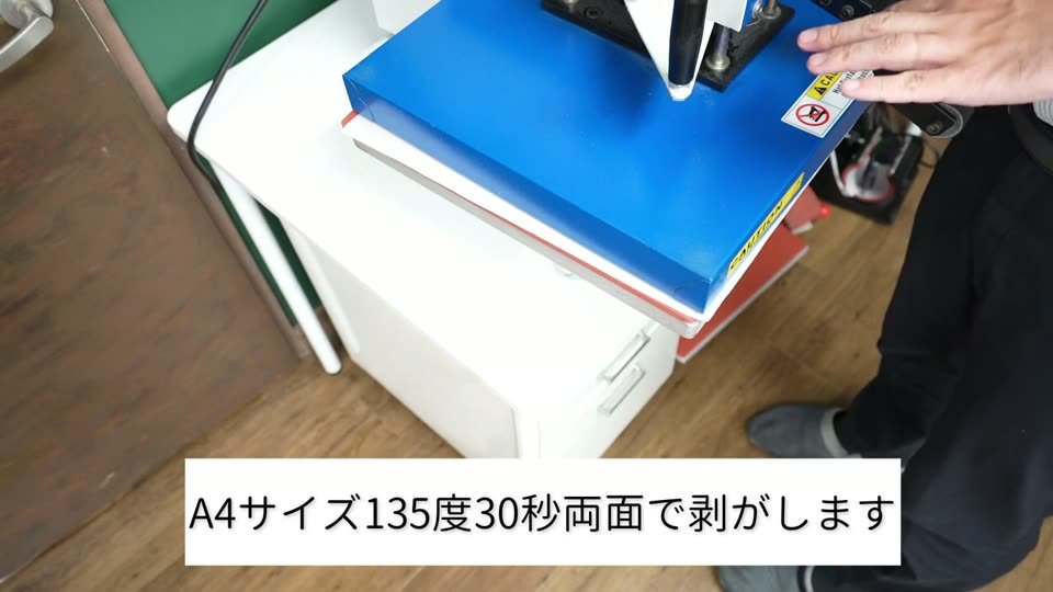 スイング式プレス機の上ゴテを閉じている。テロップはA4サイズ135度30秒両面で剥がします