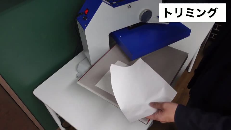 プレス台の上で剥がしたシートを持ち上げている。テロップはトリミング