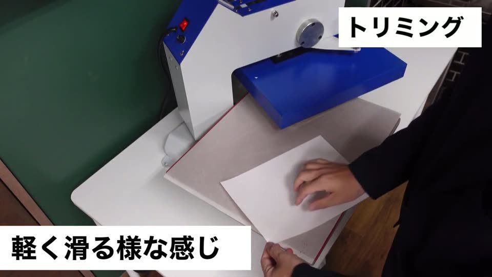 プレス台の上でシートを剥がしている手元。テロップは軽く滑る様な感じ