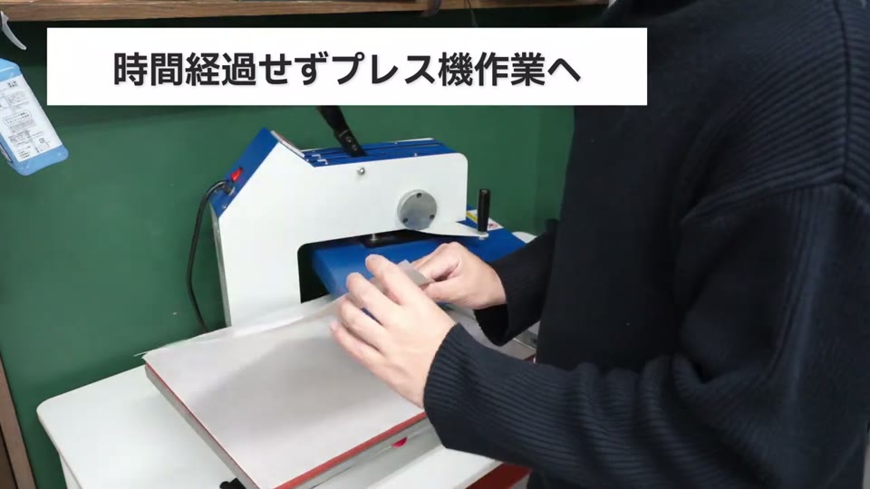 ラミネーターに通したシートをすぐにスウィング式プレス機に乗せてプレスする様子