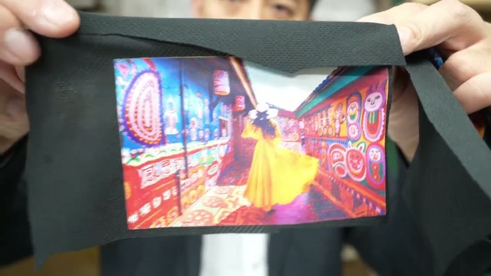 黒い生地にDTFでプリントしたカラフルな写真を手で広げて見せる様子と、WIPでしたもの、綺麗というテロップ