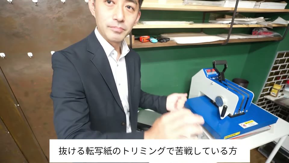 プレス機の前で転写紙を扱う様子と、抜ける転写紙のトリミングで苦戦している方というテロップ
