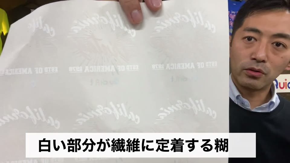 マークのシートをカメラに近づけ、「白い部分が繊維に定着する糊」とテロップが出ている場面