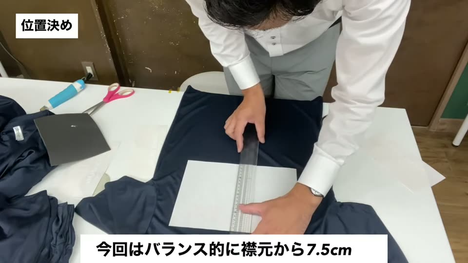 ネイビーのドライTシャツに転写紙を置き、定規で位置を測る様子。今回はバランス的に襟元から7.5cmというテロップ