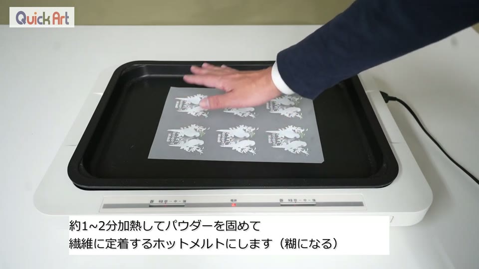 ホットプレートの上にパウダーを付けたフィルムをのせて加熱している