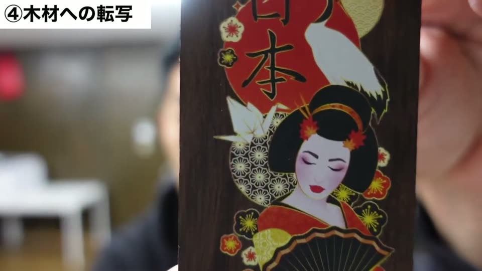 濃い茶色の木片に、日本の文字と芸者のイラストがフルカラーで転写されている